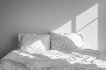 A pristine bed features crisp white linens and fluffy pillows, illuminated by gentle sunlight filtering through a window, creating a serene and inviting atmosphere in the room.