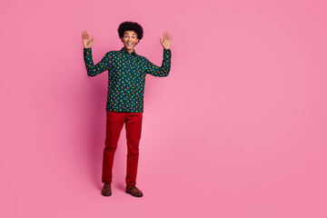 Full size photo of cool funky good mood guy with wavy hair dressed print shirt red pants raising...