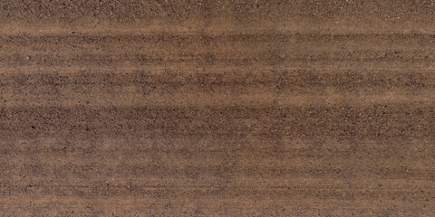 panorama view from above on texture of gravel sand road with car tire tracks