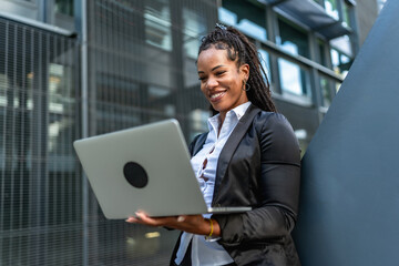 Fototapeta premium Hispanic confident businesswoman working standing outside a modern building