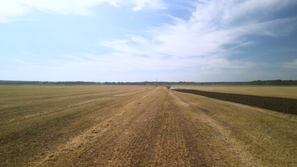 Aerial View of Tractor Plowing Farmland. Tractor and Plow Turning the Earth