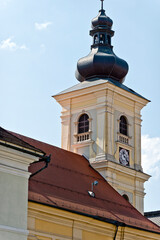 A baroque-style church tower in Sibiu, Romania, featuring an onion-shaped dome, a clock face, and arched windows.