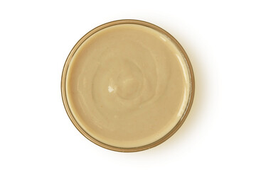 Tahini sauce in glass jar on white background