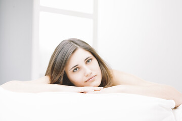Obraz premium Young woman relaxing on bed in bright room