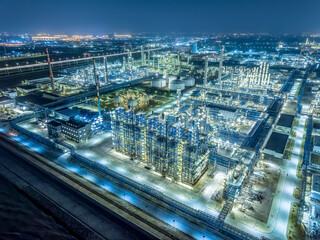Aerial shot of refinery chemical plant industrial equipment in large industrial area at night