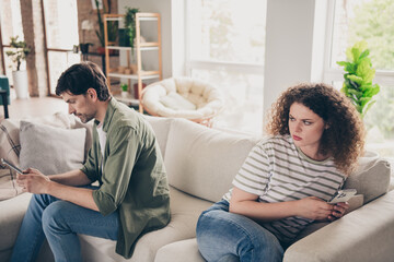 Portrait of two young partners hide smart phone chatting living room flat indoors