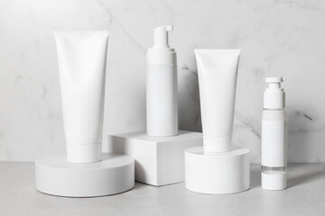 Beautiful cosmetic templates for ads, plastic cream tubes and bottles on a white background with podiums.