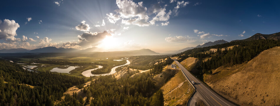 Aerial view of a tranquil sunset over the expansive wetlands and winding Columbia River surrounded by majestic mountains and serene forests, Invermere, Canada.