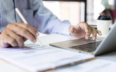 Fototapeta premium Asian businessman working with laptop at office. legal expert, professional lawyer checking business contract meeting online via laptop before giving advice to customers