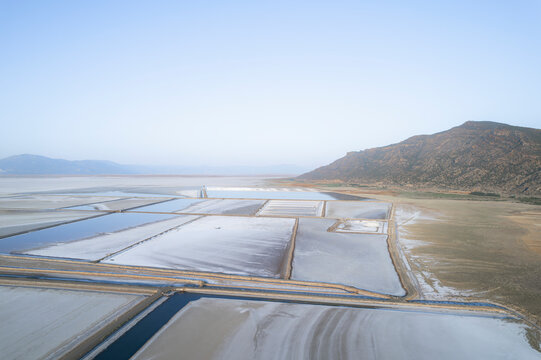 Aerial view of colorful salt farm surrounded by mountains and fields, Dazkiri, Turkey.