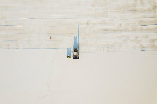 Aerial view of a minimalist salt farm with industrial machinery and vehicles, Dazkiri, Turkey.