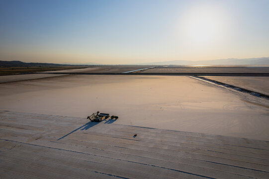 Aerial view of serene salt farm at sunrise with expansive fields and tranquil sky, Dazkiri, Turkey.