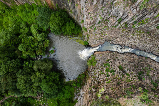 Aerial view of breathtaking basalt columns and a flowing waterfall in Prismas Basalticos Park, Huasca de Ocampo, Mexico.