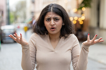 What. Why. Surprised frustrated Indian woman raising hands asking reason of failure demonstrating...