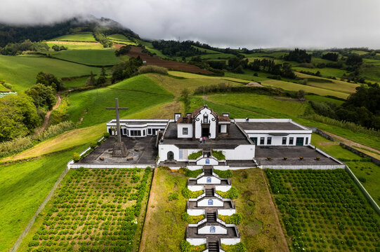 Aerial view of ermida de nossa senhora da paz church surrounded by lush greenery and tranquil hills, Vila Franca do Campo, Portugal.