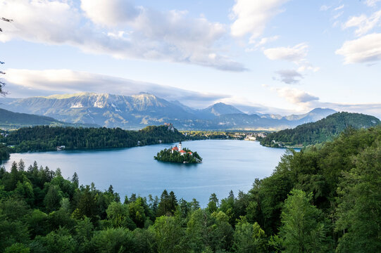 Aerial view of bled lake with the Church of the Assumption of the Blessed Virgin Mary surrounded by mountains and lush forest, Bled, Slovenia.