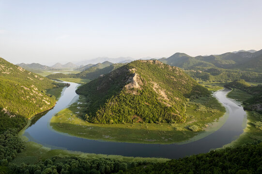 Aerial view of a picturesque winding river surrounded by lush mountains and serene valleys, Rijeka Crnojevica, Montenegro.