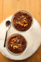 Two bowls of chia seed, chocolate and orange pudding. Healthy snack, wooden background. Top view.