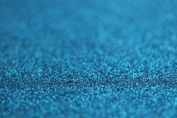 Beautiful blue glitter sparks texture as background with shallow depth of field