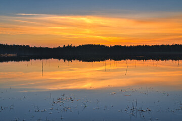 Sunset with warm colors on a Swedish lake in Smalland. Romantic evening atmosphere