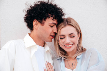 Smiling beautiful woman and her handsome boyfriend. Couple in casual summer clothes. Happy cheerful family. Female and man having fun. They posing in the street in sunny day. Having tender moments