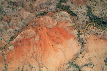 Aerial view of rugged terrain with red earth and sparse vegetation, Gascoyne Region, Australia.