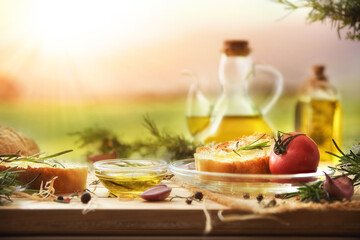 Food seasoned with rosemary-essential oil on wooden table in nature