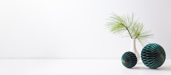 Christmas decoration in home interior, scandinavian style. Green pine branches in a vase on a white table