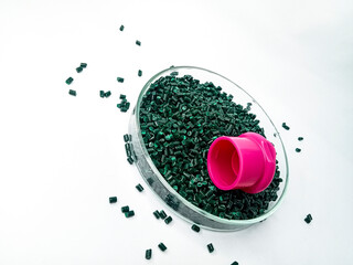 Green masterbatch granules, pigment cold cut pellet shape, in a laboratory petri dish, isolated on...