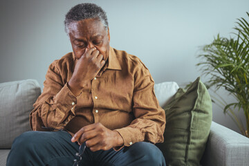 Senior Man Experiencing Stress While Sitting On A Comfortable Sofa