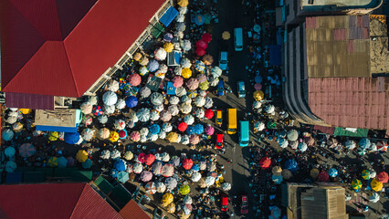Aerial view of a bustling street market with colorful umbrellas and busy vendors, Accra, Ghana.