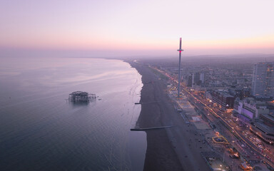 Aerial view of beautiful Brighton cityscape at sunset with bustling pier and coastline, Brighton, United Kingdom.