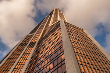 Angled view of modern skyscrapers in business district against blue sky. Looking Up high-rise...