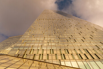 Angled view of modern skyscrapers in business district against blue sky. Looking Up high-rise...