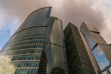 Angled view of modern skyscrapers in business district against blue sky. Looking Up high-rise...