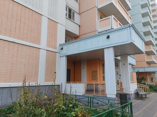 Fototapeta premium A large multi-story residential building with a pastel color palette of pink, white, and blue, featuring numerous balconies. The high-rise structure represents modern city living with an expansive