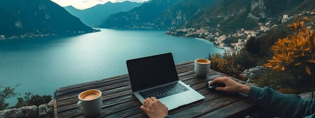 A person working on their laptop with coffee, overlooking the sea