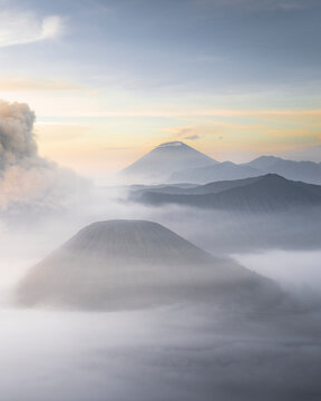 Aerial view of bromo mountain shrouded in fog and clouds at sunrise, Tosari, East Java, Indonesia.
