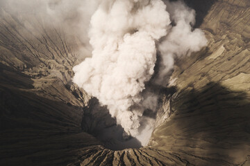 Aerial view of the active volcano with a dramatic eruption and smoky ash cloud, Sukapura, East Java, Indonesia.