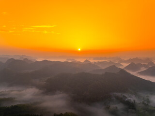 Fototapeta premium Orange sky and sea of clouds before sunrise. A peaceful, refreshing feeling. View of the hills surrounding Ba Quang, Ha Lang district, Cao Bang province, Vietnam