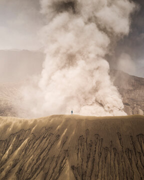 Aerial view of the majestic Mount Bromo with volcanic smoke and dramatic landscape, East Java, Indonesia.
