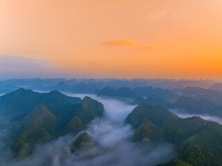 Fototapeta premium Orange sky and sea of clouds before sunrise. A peaceful, refreshing feeling. View of the hills surrounding Ba Quang, Ha Lang district, Cao Bang province, Vietnam