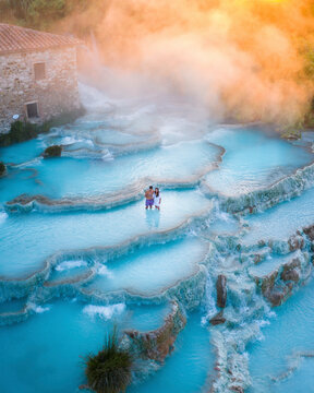 Aerial view of serene thermal springs with people in the picturesque Saturnia thermal area, Tuscany, Italy.