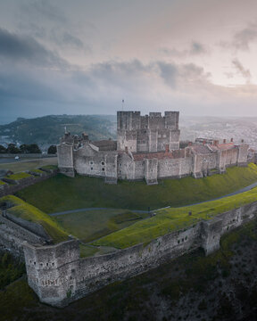 Aerial view of the majestic Dover Castle amidst a dramatic cloudy sky and beautiful countryside, Dover, England.