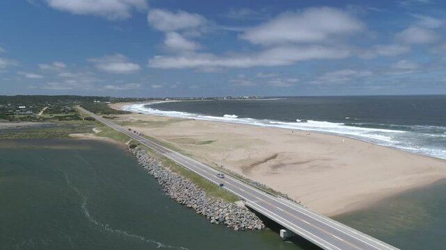 Aerial view of a beautiful coastal bridge over the serene ocean and sandy beach, Jose Ignacio, Maldonado, Uruguay.