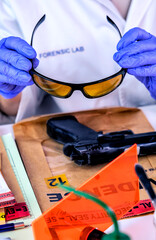 Specialized police investigating fingerprints with UV light goggles in a crime lab, concept image.