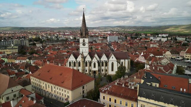 Aerial view of the historic Catedrala Evanghelică "Sf&acirc;nta Maria" in Sibiu, Romania. The church is a prominent landmark in the city and features a distinctive tall tower.