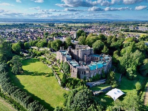Aerial view of the historic Berkeley Castle surrounded by lush greenery and a scenic landscape, Berkeley, England.