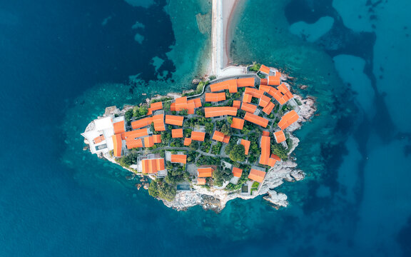 Aerial view of the historic island and old town with orange rooftops on the sveti stefan peninsula, Budva, Montenegro.