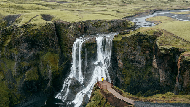 Aerial view of the breathtaking Fagrifoss waterfall cascading down a cliff surrounded by lush greenery, Skaftarhreppur, Iceland.